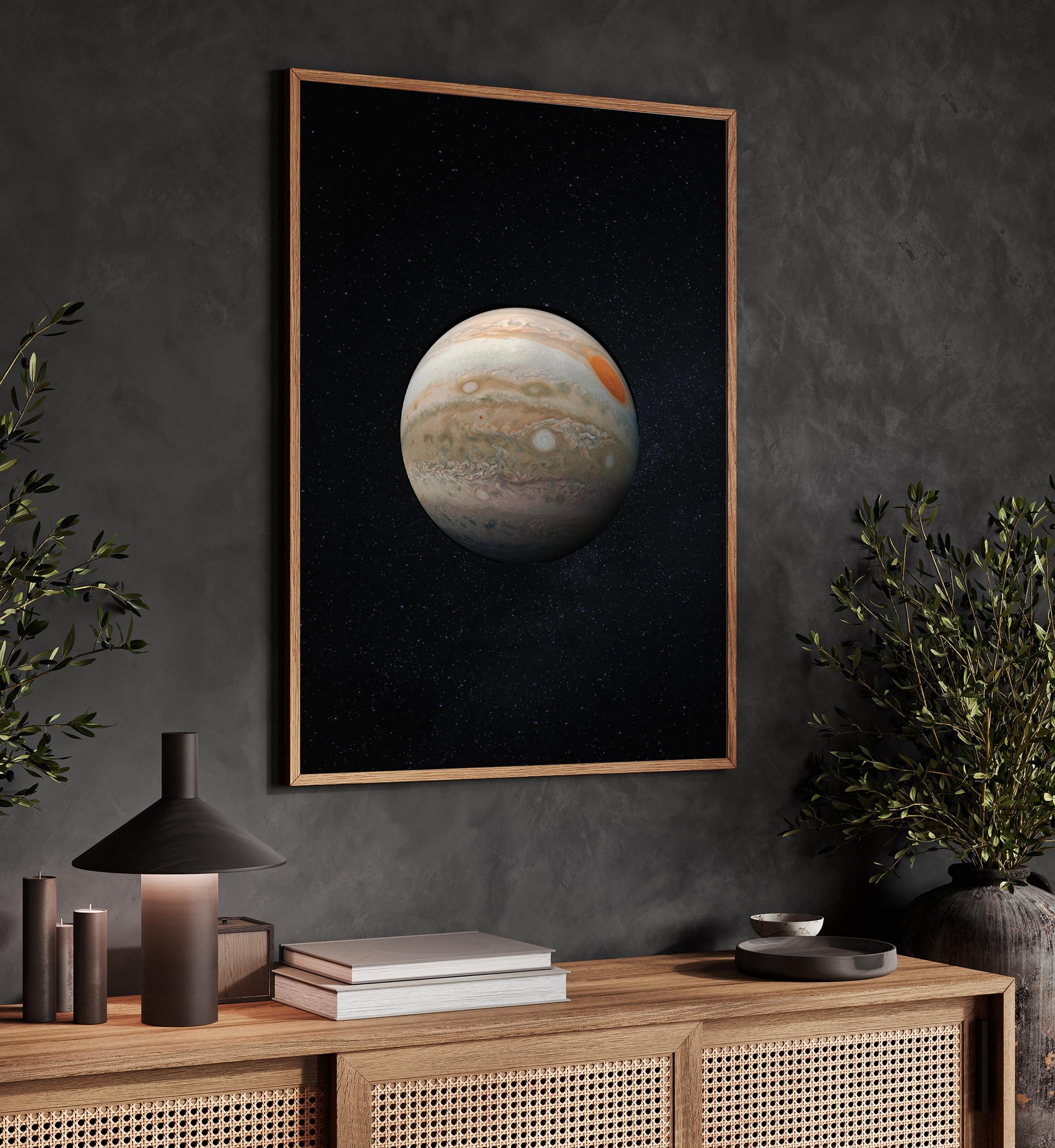 a framed poster of a planet hanging on a wall, with a wooden cabinet below it and some decorative elements such as a lamp and a plant.