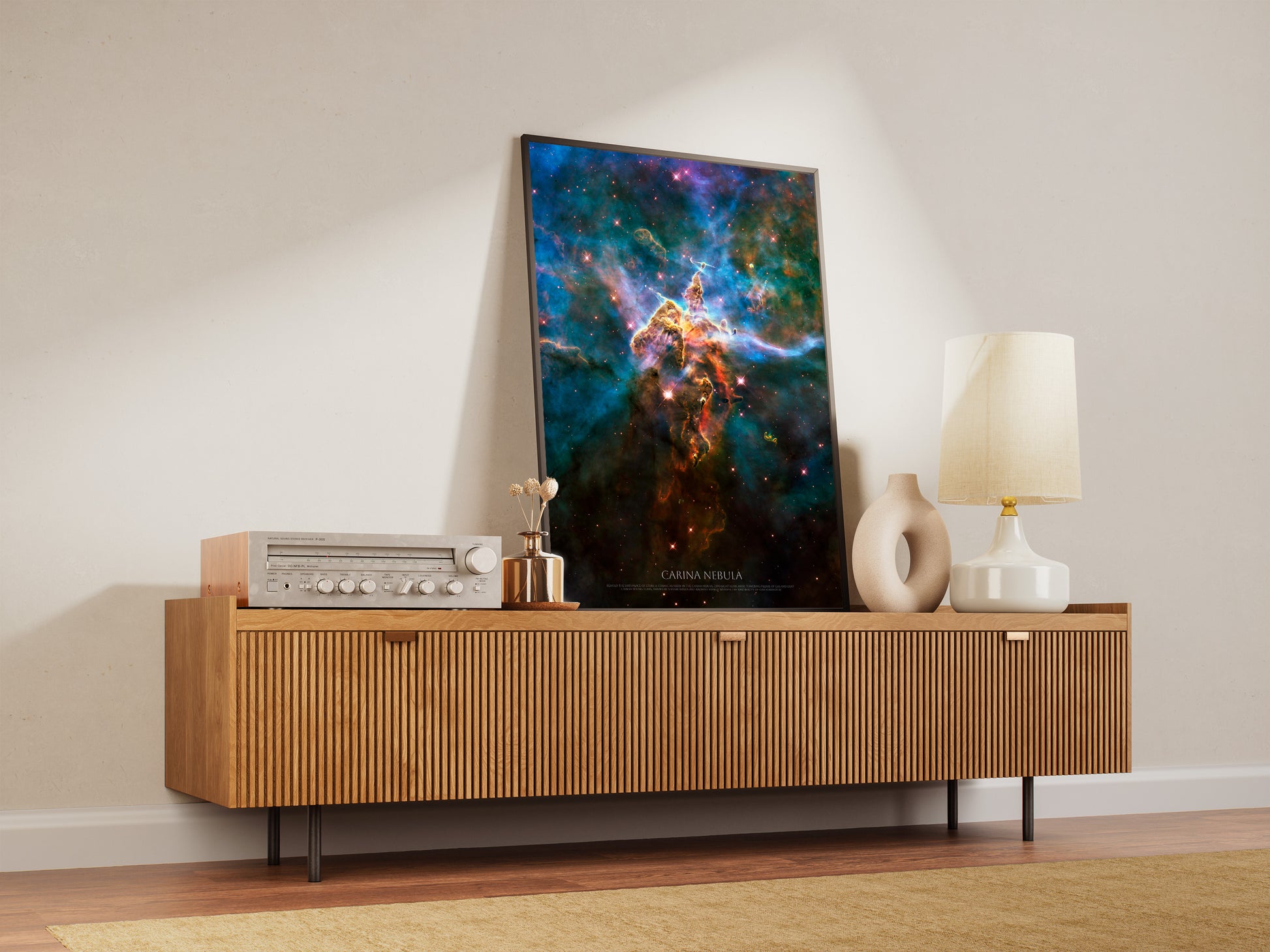 a wooden entertainment center with a framed poster of a colorful nebula hanging on it. The entertainment center has a lamp and a radio on top of it.