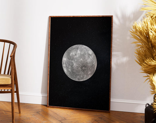 a large framed picture of the moon against a black background, placed on a wooden floor next to a wooden chair.