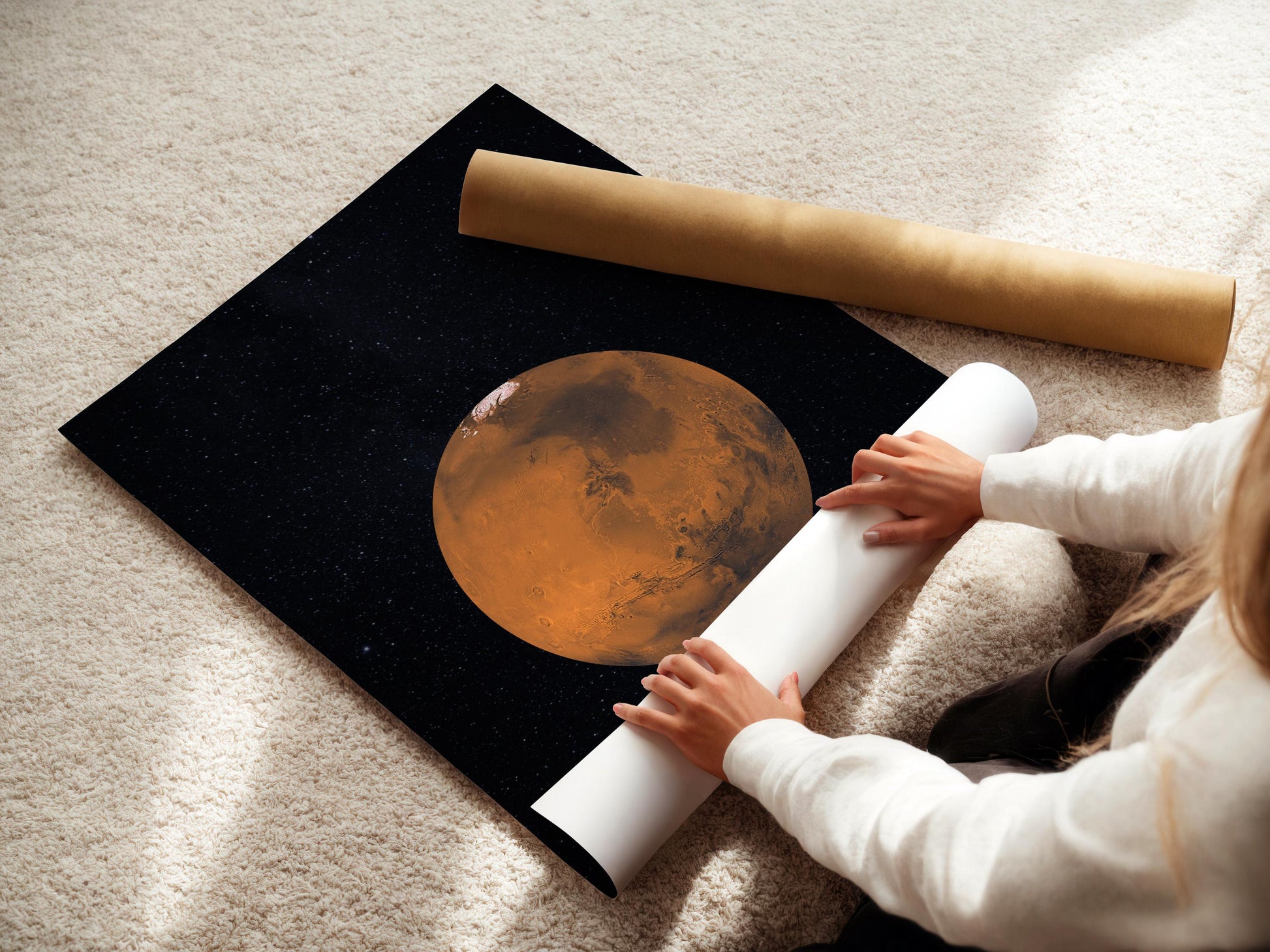 A person is placing a large poster featuring a planet on a carpeted floor.