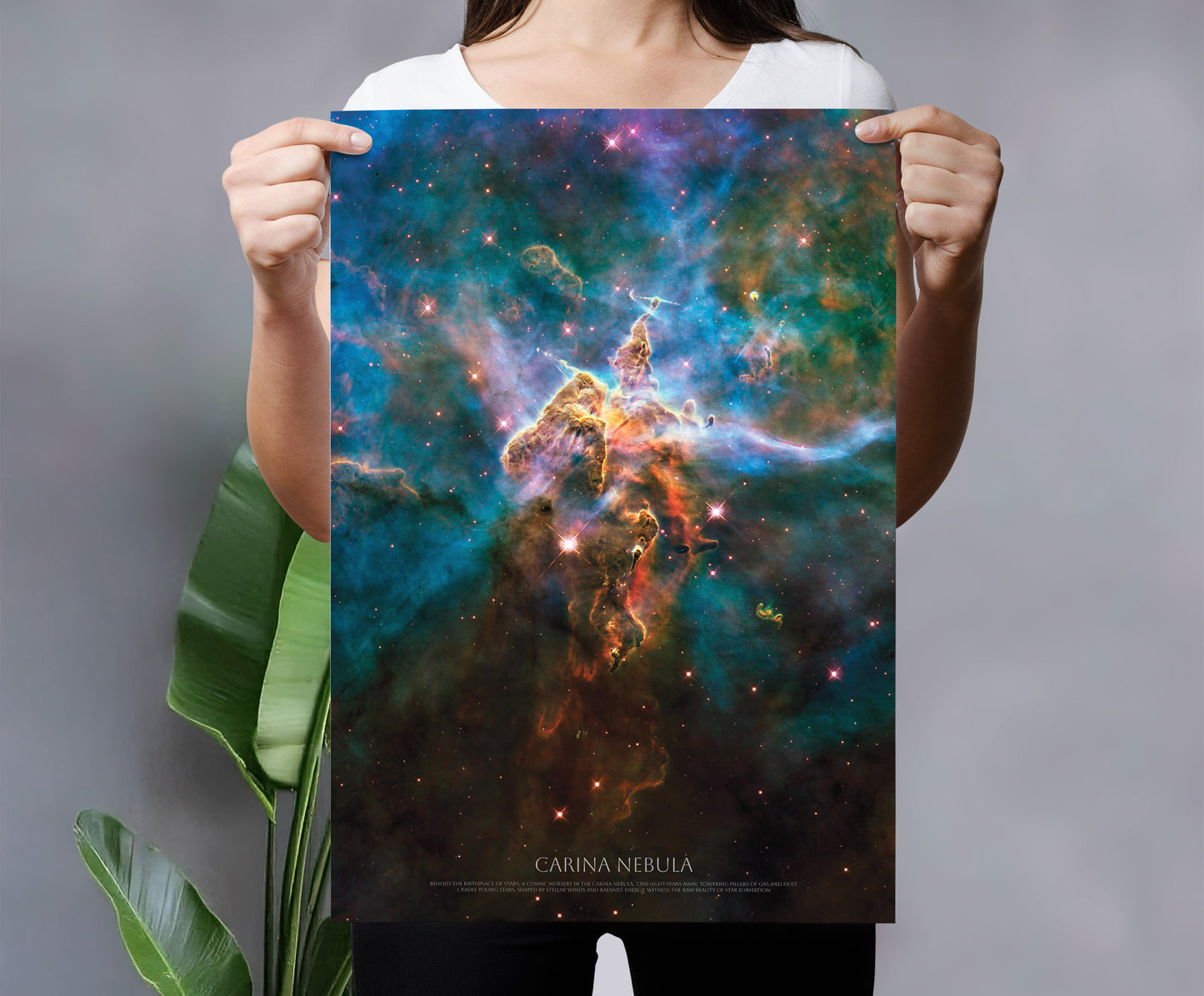 A person is holding up a poster of the Carina Nebula, a famous nebula in the Large Magellanic Cloud.