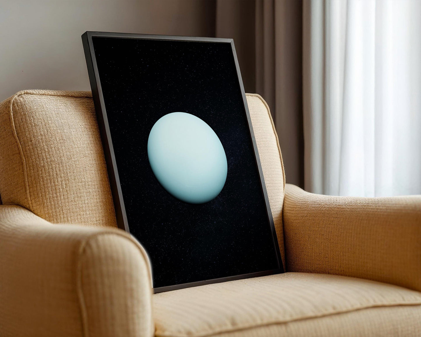 A framed image of a blue planet is displayed on the armrest of a beige armchair.