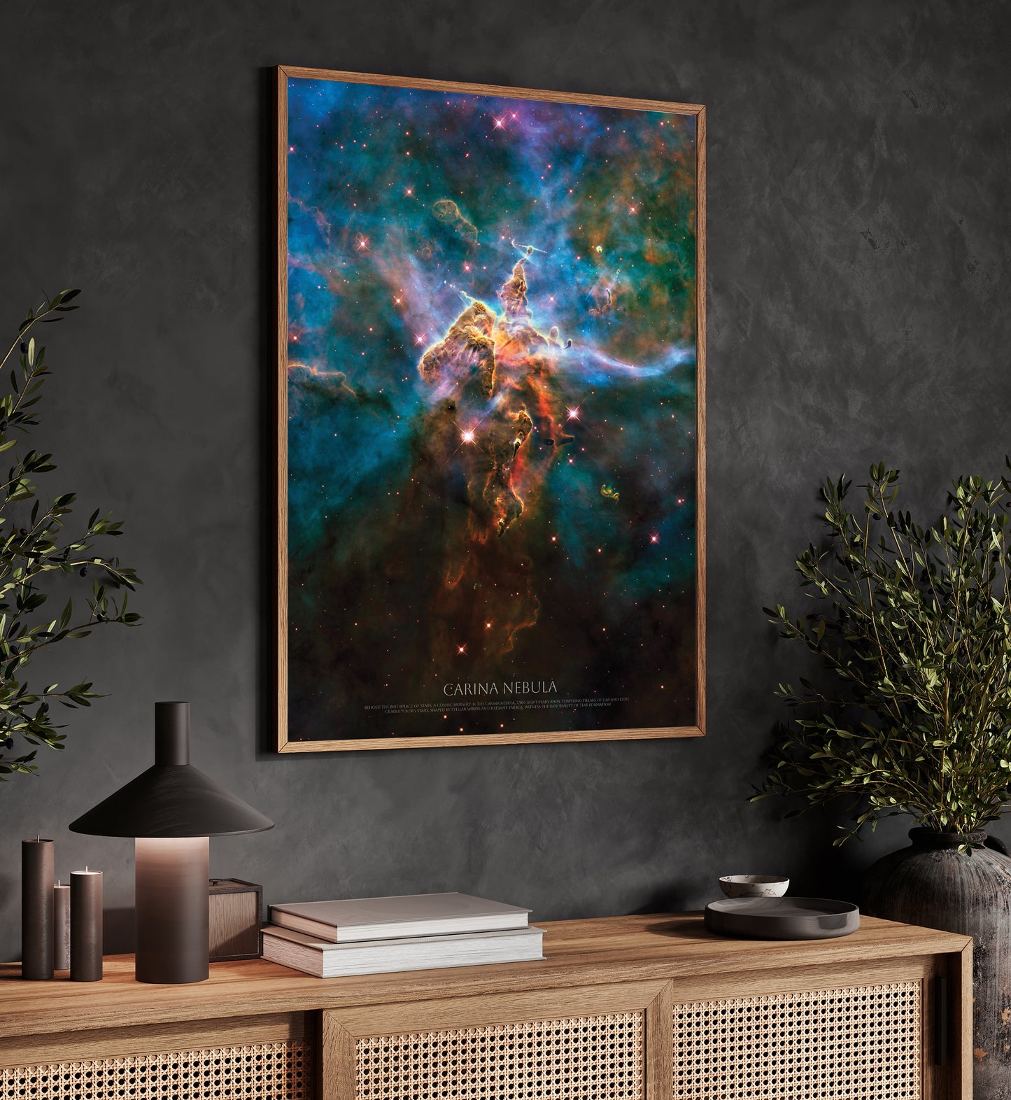 a framed poster of a colorful nebula hanging on a wall above a wooden cabinet with various items on top, including a lamp, a plant, and some books.