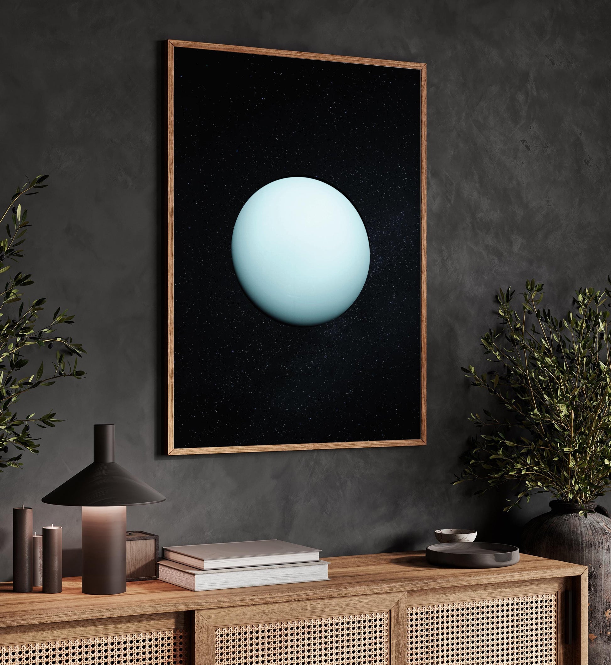 a dark wooden cabinet with a framed artwork of a blue planet hanging on the wall above it. The cabinet also has a lamp and a plant on top of it.
